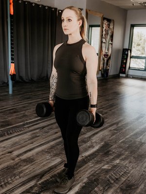 woman holding two dumbbells
