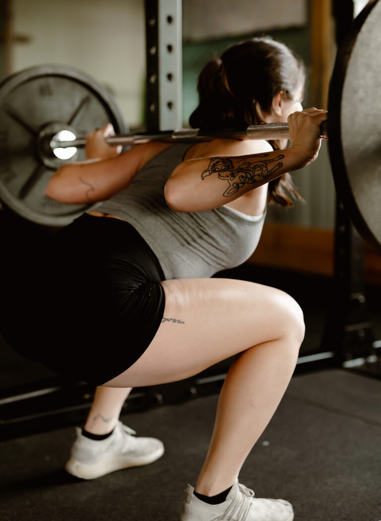 woman performing a squat with barbell