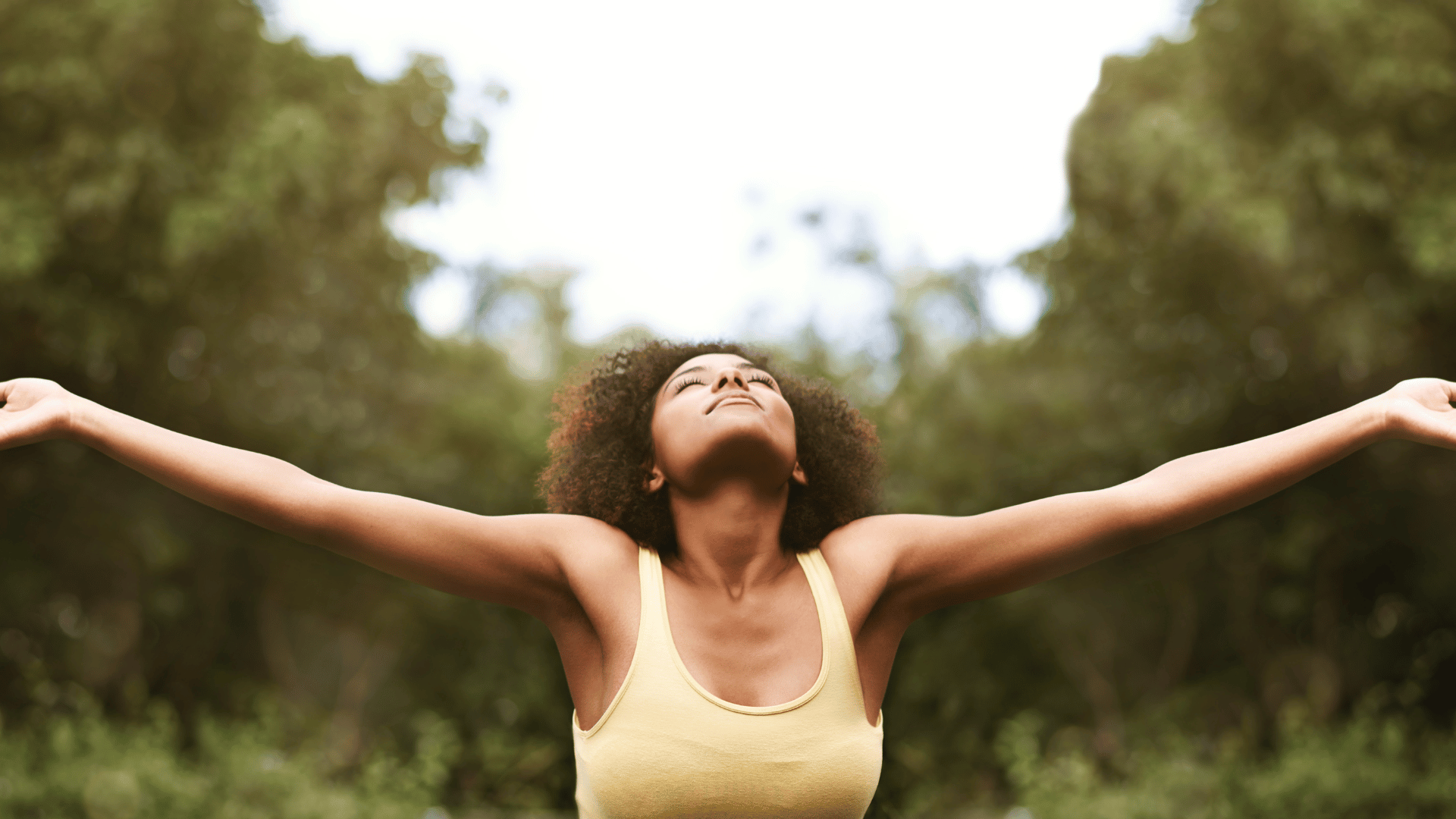 woman with arms outstretched and joyful
